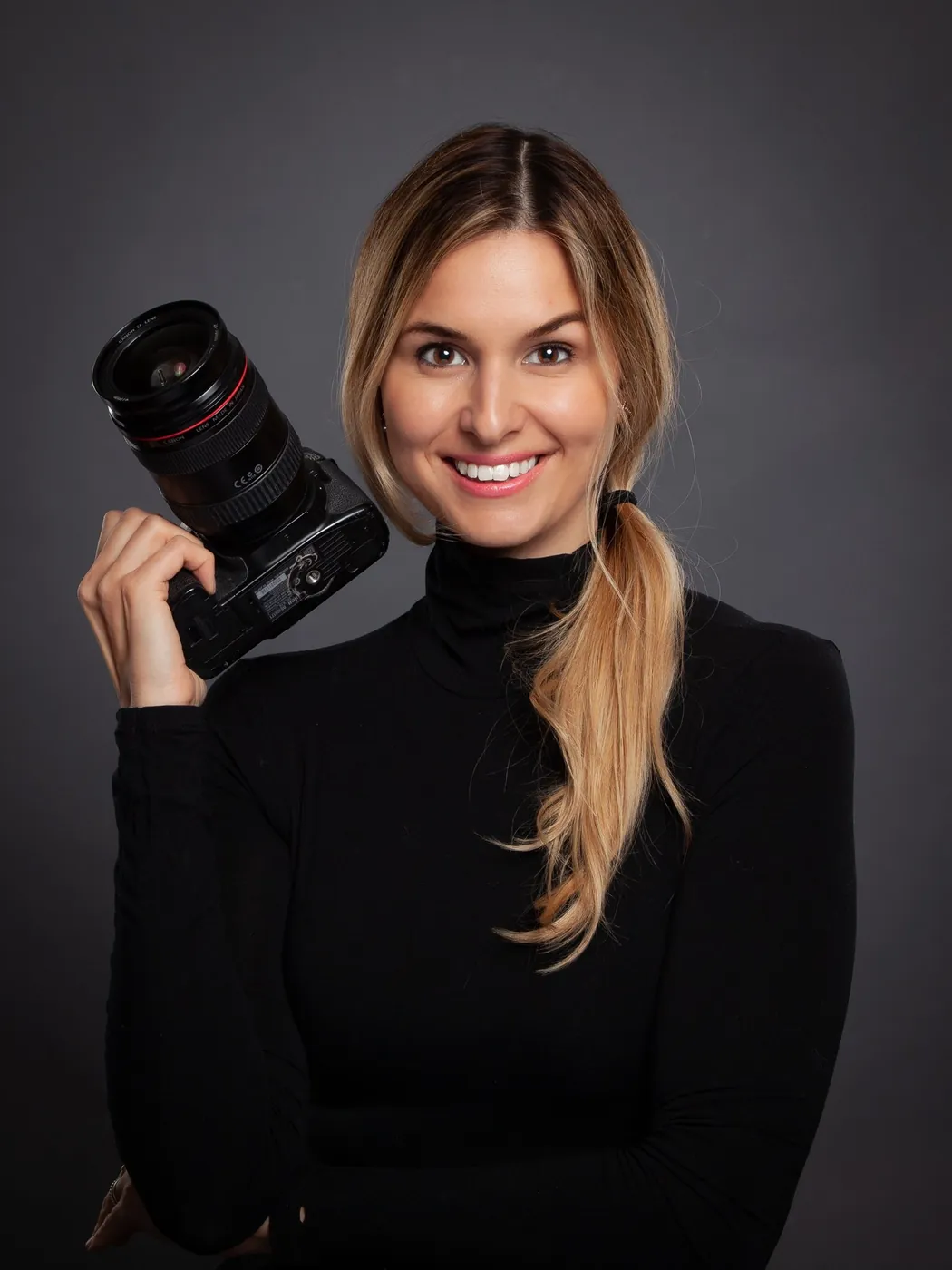 Portrait of the photographer behind By Sari holding her camera